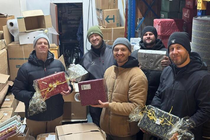 Helfer mit Weihnachtsgeschenken beim Beladen