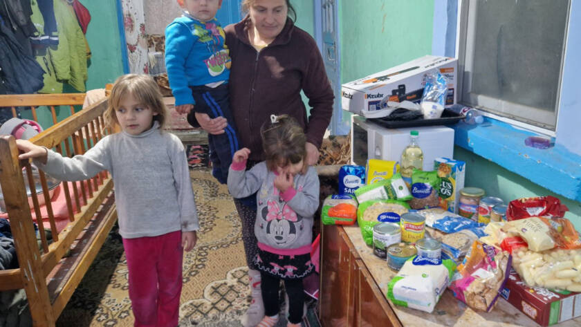 Kinder und Mutter neben den übergebenen Lebensmitteln