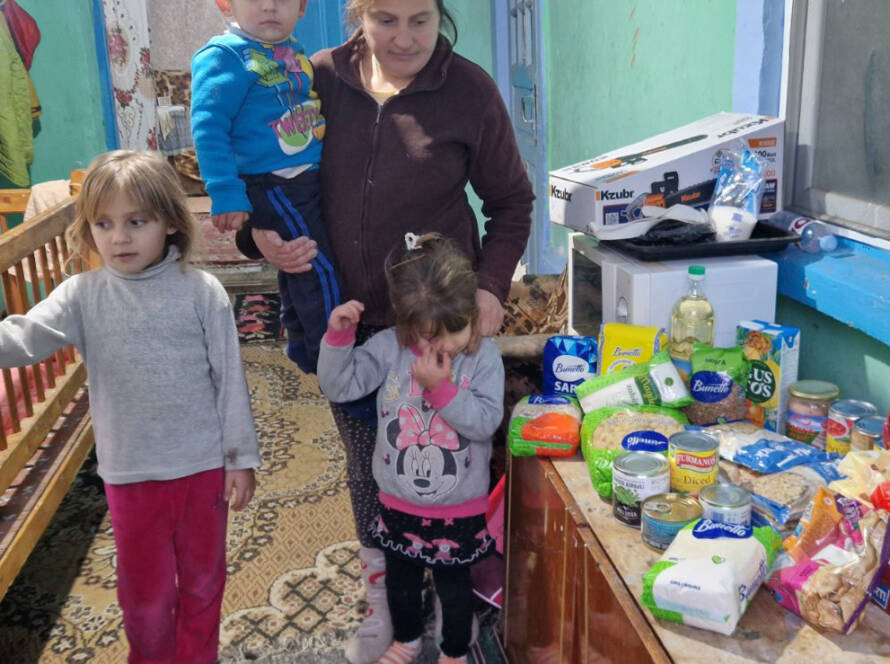 Kinder und Mutter neben den übergebenen Lebensmitteln