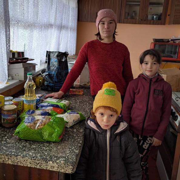 Mutter mit Kindern und Lebensmitteln in der Küche