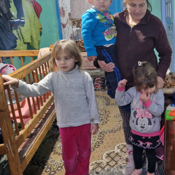 Kinder und Mutter neben den übergebenen Lebensmitteln